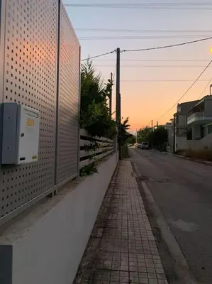 a fence on the side of a street next to a road at Vasiliki’s Guesthouse II in Athens