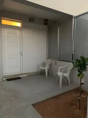a room with two chairs and a table and a door at Vasiliki’s Guesthouse II in Athens