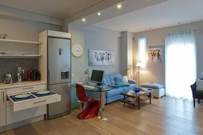a living room with a couch and a table with a laptop at Acropolis Luxury Apartment with Balcony in Athens