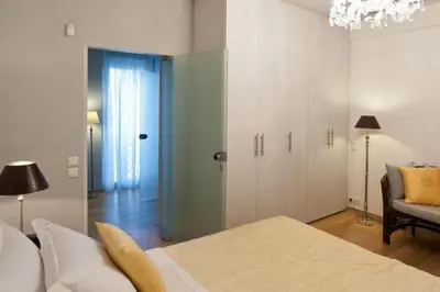 a bedroom with a bed and a couch and a chandelier at Acropolis Luxury Apartment with Balcony in Athens