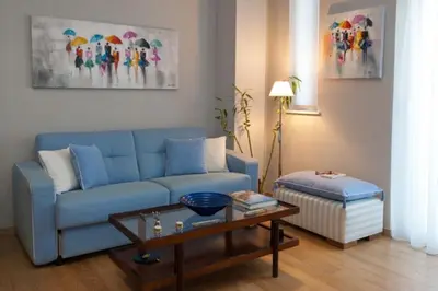 a living room with a blue couch and a table at Acropolis Luxury Apartment with Balcony in Athens