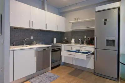 a kitchen with white cabinets and a refrigerator at Acropolis Luxury Apartment with Balcony in Athens