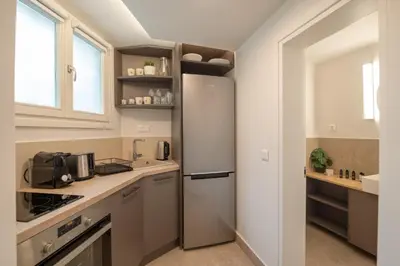 a small kitchen with a refrigerator and a window at Plaka Apartments - Acropolis View in Athens
