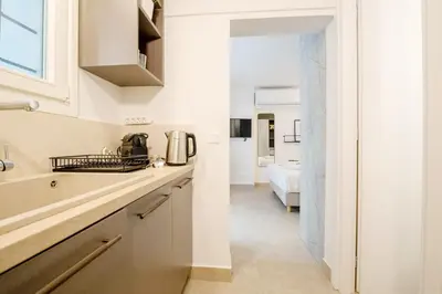 a kitchen with white cabinets and a sink at Plaka Apartments - Acropolis View in Athens