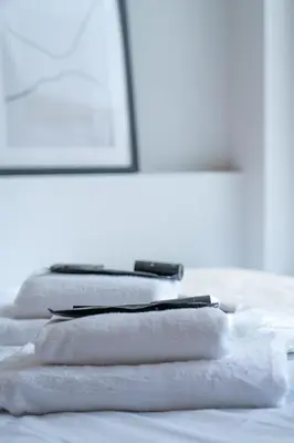 a pile of white towels sitting on top of a bed at Plaka Apartments - Acropolis View in Athens