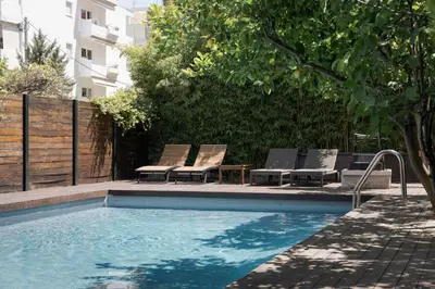 a swimming pool with two chairs and a table at Lussuosa Villa Glyfada in Athens