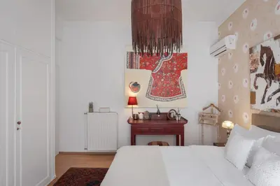 a bedroom with a white bed and a fireplace at Lussuosa Villa Glyfada in Athens
