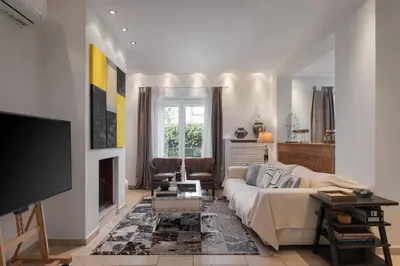 a living room with a couch and a tv at Lussuosa Villa Glyfada in Athens