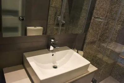 a bathroom with a white sink and a mirror at Apartment in Kolonaki in Athens