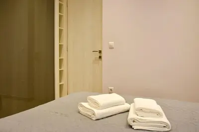 two white towels sitting on top of a bed at Apartment in Kolonaki in Athens