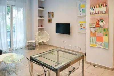 a living room with a glass table and a tv at Apartment in Kolonaki in Athens