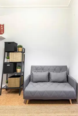 a gray couch in a room with a white wall at Cosy Central Apartment in Plaka in Athens