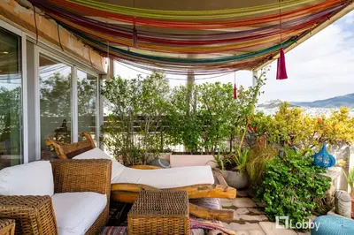 a screened in porch with a couch and chairs at OBSRV Penthouse by LobbySquare in Athens