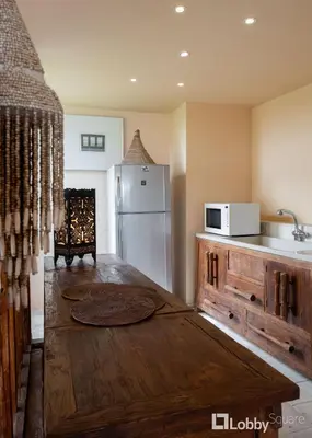 a kitchen with a wooden table and a white refrigerator at OBSRV Penthouse by LobbySquare in Athens