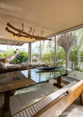 a living room with a glass table and a large window at OBSRV Penthouse by LobbySquare in Athens