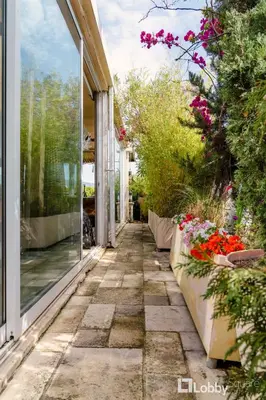 a walkway in front of a house with flowers at OBSRV Penthouse by LobbySquare in Athens