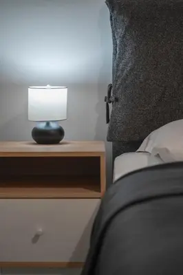 a lamp on a night stand next to a bed at Oculus Gelonos 1 BD City Apartment by Live&Travel in Athens