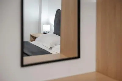 a mirror on a wall next to a bed at Oculus Gelonos 1 BD City Apartment by Live&Travel in Athens