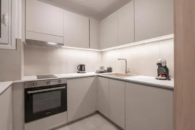 a white kitchen with a sink and a stove at Oculus Gelonos 1 BD City Apartment by Live&Travel in Athens