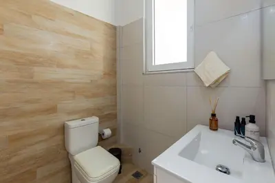 a bathroom with a toilet and a sink and a window at Holodek Apartments : Akropolis in Athens
