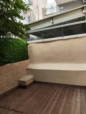 a building with a wooden deck with a staircase at Star Hostel in Piraeus