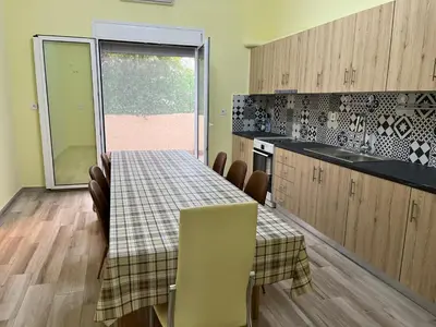 a kitchen with a table and chairs and a window at Star Hostel in Piraeus