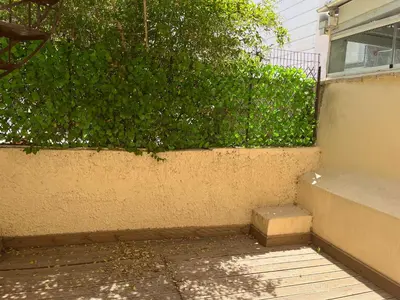 a green bush next to a wall with a staircase at Star Hostel in Piraeus