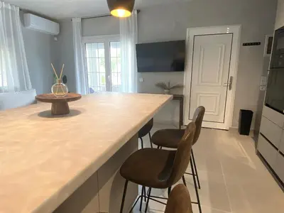 a kitchen with two bar stools and a counter top at Arcus by Aestas Suites in Artemida
