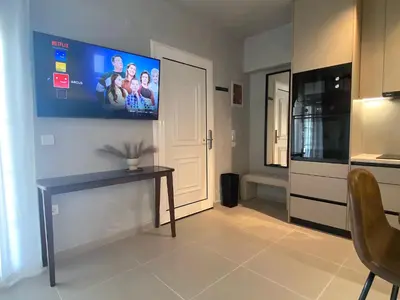 a living room with a table and a tv on the wall at Arcus by Aestas Suites in Artemida