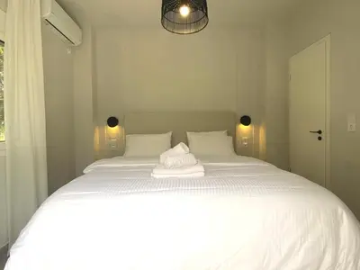 a white bed with a towel on top of it at Arcus by Aestas Suites in Artemida