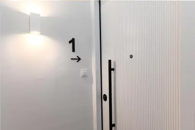 a clock on the wall next to a door at Serene 1BR Apartment in the Heart of Athens in Athens