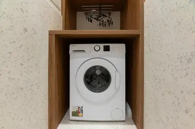a washer and dryer in a wooden cabinet at Serene 1BR Apartment in the Heart of Athens in Athens
