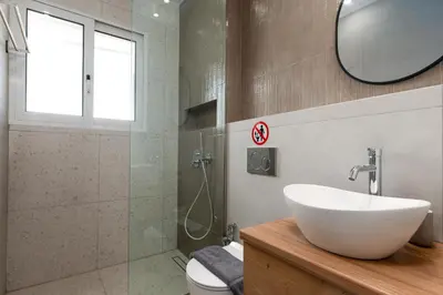 a bathroom with a white sink and a shower at Serene 1BR Apartment in the Heart of Athens in Athens