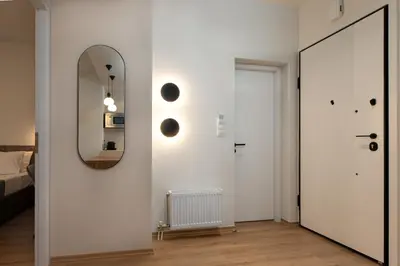 a white room with a mirror and a door at Serene 1BR Apartment in the Heart of Athens in Athens