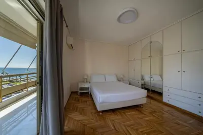 a bedroom with a bed and a view of the ocean at Coral Three-Bedroom Apartments with Sea View and Balcony in Athens