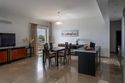 a kitchen and dining room with a table and chairs at Coral Three-Bedroom Apartments with Sea View and Balcony in Athens