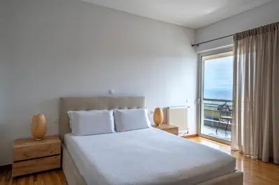 a bedroom with a bed with a view of the ocean at Coral Three-Bedroom Apartments with Sea View and Balcony in Athens
