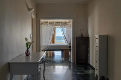 a room with a window with a desk and a table at Coral Three-Bedroom Apartments with Sea View and Balcony in Athens