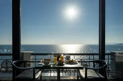 a table with food on a balcony with a view of the ocean at Coral Three-Bedroom Apartments with Sea View and Balcony in Athens