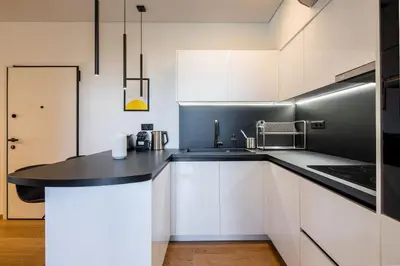 a kitchen with white cabinets and a black counter top at Bloom - Luxury 2-Bedroom Apartment in Athens in Athens