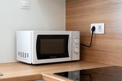 a microwave sitting on a counter next to a phone at Calm 1BR Apartment in the Heart of Athens in Athens