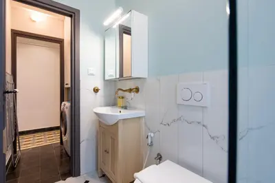 a bathroom with a sink and a toilet and a mirror at Meadows - Luxury 3-Bedroom Apartment in Athens in Athens