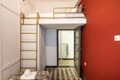 a room with two bunk beds and a red wall at Meadows - Luxury 3-Bedroom Apartment in Athens in Athens