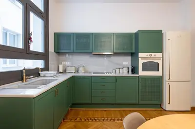 a kitchen with green cabinets and a white refrigerator at Meadows - Luxury 3-Bedroom Apartment in Athens in Athens