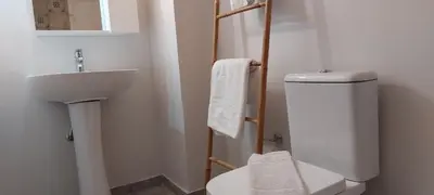 a bathroom with a white toilet and a sink at Magnolia Apartment -4BD , 1.5 BT in Athens