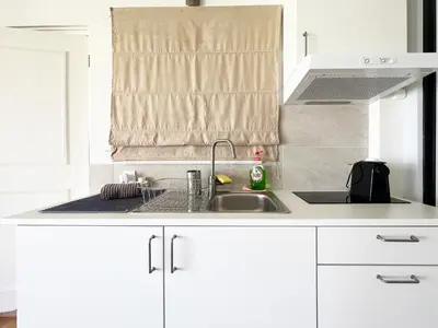 a kitchen with white cabinets and a sink at Riviera View in Athens