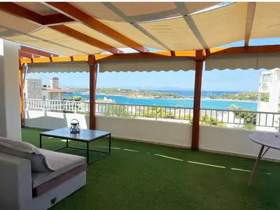 a balcony with a couch and a view of the ocean at Riviera View in Athens