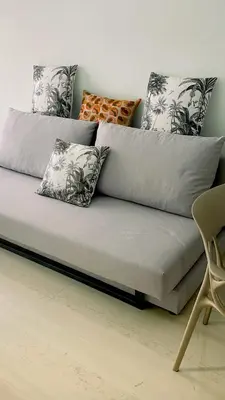 a gray couch with pillows on it in a room at Blue harbour house - style meets comfort in Piraeus