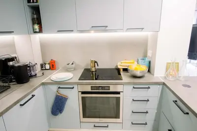 a kitchen with white cabinets and a stove top oven at Blue harbour house - style meets comfort in Piraeus