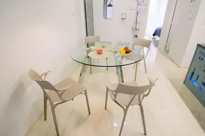 a glass table and chairs in a room at Blue harbour house - style meets comfort in Piraeus